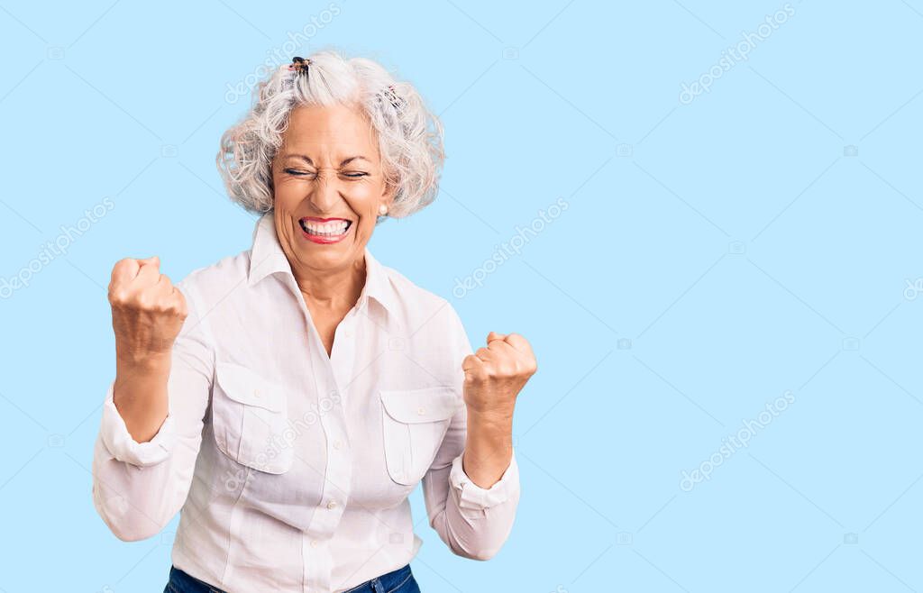 Senior grey-haired woman wearing casual clothes very happy and excited doing winner gesture with arms raised, smiling and screaming for success. celebration concept. 