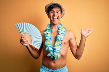 Mayoyla gezen genç turist ve Hawaii çiçekleri el ele tutuşuyor çok mutlu ve heyecanlı, kazanan yüz ifadesi zaferi büyük bir gülümsemeyle kutluyor ve ellerini kaldırıyor.