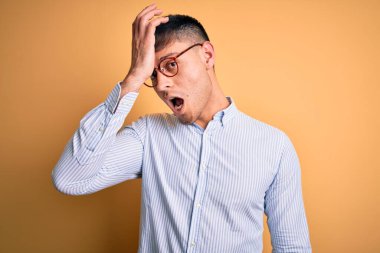 Sarı arka planda inek gözlüğü takan genç, yakışıklı İspanyol iş adamı. Hatayla el ele tutuşurken şaşırdı, unutma. Unuttum, kötü hafıza konsepti.