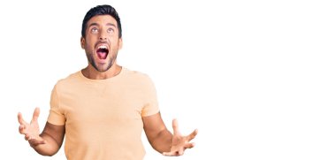 Gündelik kıyafetler giyen genç İspanyol adam deli gibi bağırıyor ve agresif bir ifade ve kollarla bağırıyor. hüsran kavramı. 
