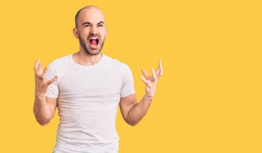 Genç, yakışıklı bir adam rahat tişört giyiyor. Deli gibi bağırıyor, agresif bir ifadeyle bağırıyor ve kollarını kaldırıyor. hüsran kavramı. 