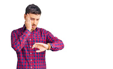 Ayılı yakışıklı genç adam, sıradan bir gömlek giyiyor. Saate bakıyor. Endişeli, geç kalmaktan korkuyor. 