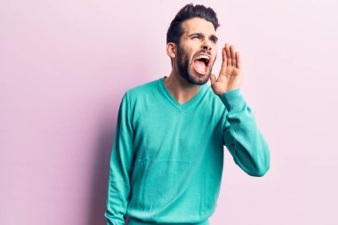 Sakallı, sıradan bir süveter giyen genç, yakışıklı bir adam el ele verip bağırıyor. iletişim konsepti. 