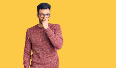 Kış süveteri giyen ve gözlük takan genç, yakışıklı İspanyol adam pis ve iğrenç bir koku alıyor. Nefesini burnu havada tutuyor. Kötü kokuyor. 