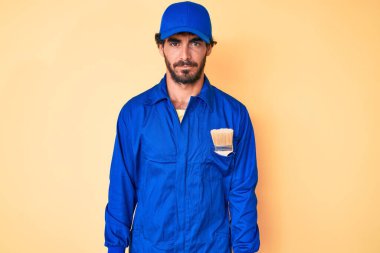 Kıvırcık saçlı, ayı kılıklı, inşaatçı tulumu giyen, kuşkucu ve gergin, sorunlardan dolayı suratını asan yakışıklı bir genç. negatif kişi. 