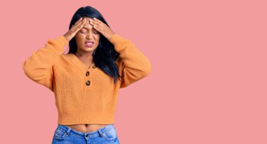 Uzun saçlı İspanyol kadın stresten dolayı elleri başının üstünde, günlük kışlık süveter giyiyor. migren ağrısı. 