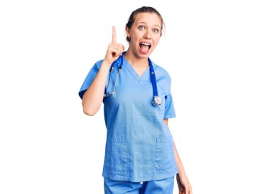 Doktor üniforması giyen güzel sarışın bir kadın ve steteskop başarılı bir fikirle işaret ediyor. Heyecanlı ve mutlu. Bir numara.. 