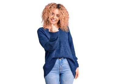 Kıvırcık saçlı, sıradan bir süveter giyen genç sarışın kadın seni buraya davet ediyor. 