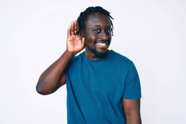 Saçları günlük kıyafetlerle gezen, ağzı kulaklarına varan gülümseyerek dedikodu ve dedikoduları dinleyen Afro-Amerikalı genç bir adam. Sağırlık kavramı. 