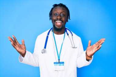 Doktor steteskopu ve kimlik kartı takan genç Afrikalı Amerikalı adam zaferi mutlu bir gülümsemeyle ve ellerini kaldırarak kutluyor. 