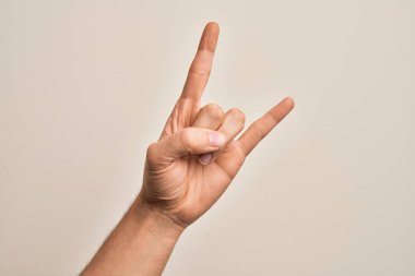 Beyaz arka planda parmaklarını gösteren beyaz tenli bir gencin eli. Rock 'n Roll sembolü, müstehcen boynuzlar gösteriyor.