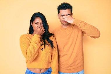 Güzel Latin bir çift, günlük kıyafetlerini giyip pis ve iğrenç bir koku aldılar. Nefeslerini burunlarında tutuyorlardı. Kötü kokuyor. 