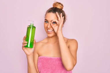 Mavi gözlü güzel sarışın kadın banyo üstüne duş alıyor mutlu yüzlü aloe vera jeli tutuyor tamam işaret veriyor parmaklarının arasından bakıyor