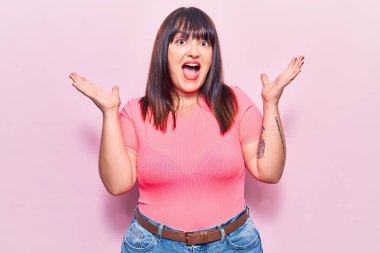 Genç ve cüsseli bir kadın çılgın kutlamalar yapıyor ve başarıya hayret ediyor. Kolları açık, gözleri açık, heyecanlı çığlıklar atıyor. Kazanan konsept 