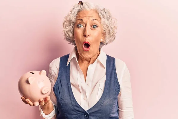 Senior Grauhaarige Frau Hält Sparschwein Verängstigt Und Erstaunt Mit Offenem — Stockfoto