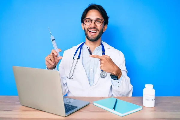 Handsome Hispanic Doctor Man Clinic Holding Syringe Smiling Happy Pointing — Stock Photo, Image