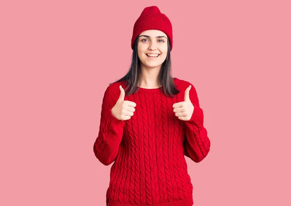 Junge Schöne Mädchen Pullover Und Wollmütze Erfolgszeichen Tun Positive Geste — Stockfoto