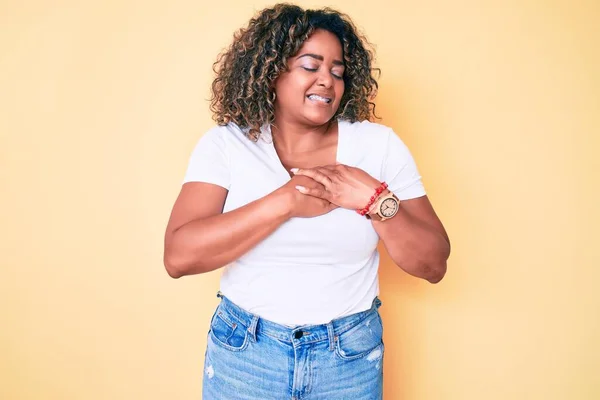 若いアフリカ系アメリカ人のプラスサイズの女性が目を閉じて胸に手で笑みを浮かべてカジュアルな白いTシャツを着て顔に感謝のジェスチャー 健康の概念 — ストック写真