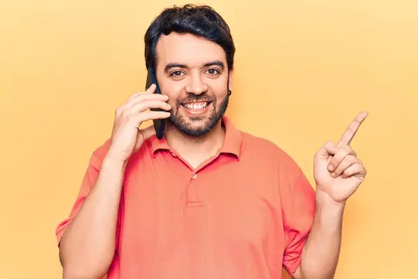 Jovem Hispânico Homem Conversando Smartphone Sorrindo Feliz Apontando Com Mão — Fotografia de Stock