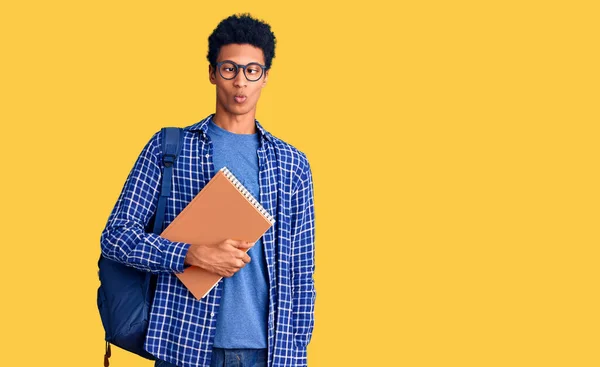 Jovem Afro Americano Usando Mochila Estudantil Segurando Livro Fazendo Cara — Fotografia de Stock