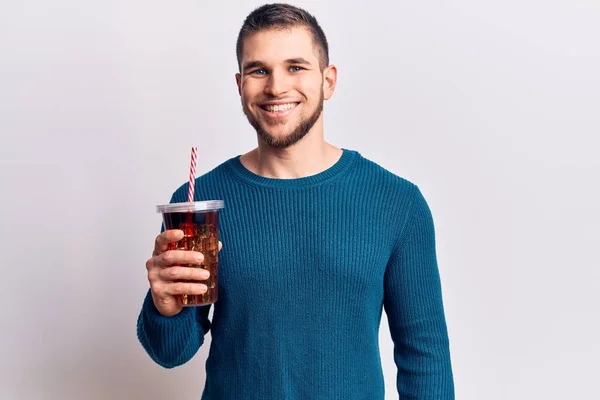 若いですハンサムな男はコーラのリフレッシュ飲料を飲みますポジティブで幸せな立っていると笑顔で自信を持って笑顔を見せ歯 — ストック写真