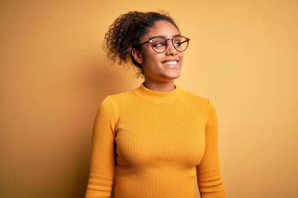 Молодая Красивая Африканская Американка Свитере Очках Жёлтом Фоне Смотрит Сторону — стоковое фото