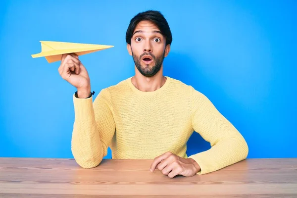 Bonito Homem Hispânico Segurando Avião Papel Assustado Surpreso Com Boca — Fotografia de Stock