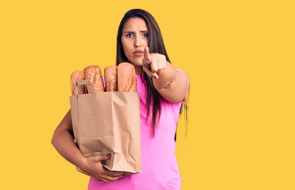 Joven Mujer Morena Hermosa Sosteniendo Bolsa Parto Con Pan Señalando — Foto de Stock