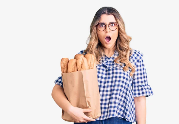 Jonge Blanke Vrouw Met Papieren Zak Met Brood Bang Verbaasd — Stockfoto