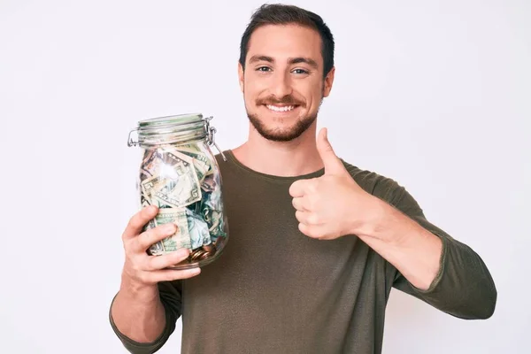 Jovem Bonito Homem Segurando Jar Com Poupança Sorrindo Feliz Positivo — Fotografia de Stock