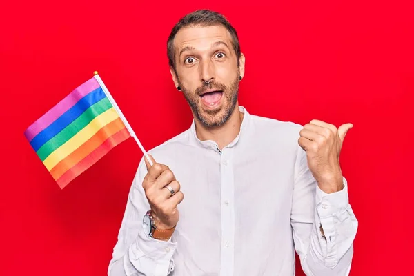 Joven Hombre Guapo Sosteniendo Arco Iris Lgbtq Bandera Apuntando Pulgar — Foto de Stock