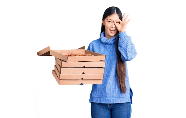 若いです美しいです中国人女性保持段ボール箱のイタリアのピザ笑顔幸せな行いますOkサインとともに手で目を通して見て指 — ストック写真