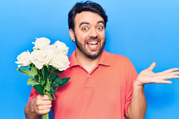 幸せな笑顔で達成を祝う花を保持している若いヒスパニック系の男と受賞式とともに上げ手 — ストック写真