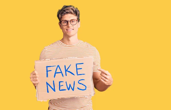 Young Handsome Man Holding Fake News Banner Smiling Happy Pointing — ストック写真