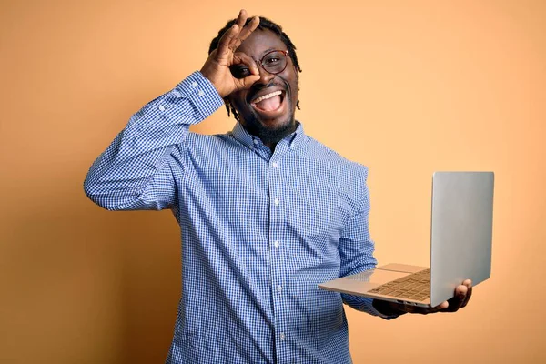 若いですアフリカ系アメリカ人労働者の男作業ノートパソコンを使用して黄色の背景の上に立って幸せな顔笑顔をします — ストック写真