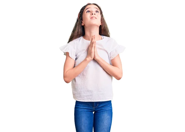 かわいいヒスパニック系の子供の女の子は非常に感情的かつ心配の顔に希望の表現と一緒に手で物乞いや祈りをカジュアルな白いTシャツを着て お願い — ストック写真