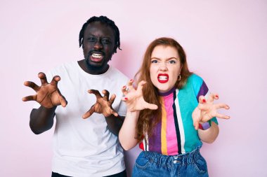 Farklı ırktan çiftler günlük kıyafetler giyip gülüyorlar. Pençe hareketlerini kedi gibi yapıyorlar. Agresif ve seksi bir ifade. 