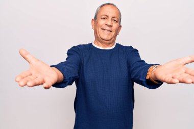 Gri saçlı, sıradan bir kazak giyen son sınıf öğrencisi kameraya bakıp sarılmak için kollarını açmış gülümsüyor. Mutluluğu kucaklayan neşeli bir ifade.. 