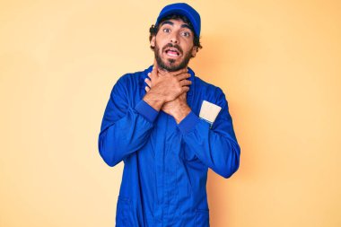 Kıvırcık saçlı, ayı kılıklı, işçi tulumu giyen yakışıklı genç adam bağırıyor ve boğuluyor çünkü acı verici bir boğulma. Sağlık problemi. Boğulma ve intihar konsepti. 