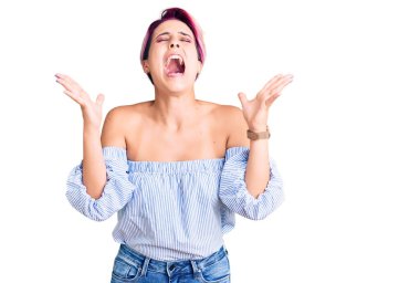 Young beautiful woman with pink hair wearing casual clothes celebrating mad and crazy for success with arms raised and closed eyes screaming excited. winner concept  clipart