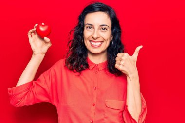 Genç, güzel İspanyol bir kadın, güler yüzle gülümsüyor, mutlu ve pozitif, başparmak yukarı, mükemmel ve onay işareti yapıyor. 