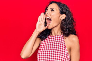 Orta yaşlı, kolsuz tişört giyen güzel bir kadın el ve ağızla bağırıyor ve bağırıyordu. iletişim konsepti. 