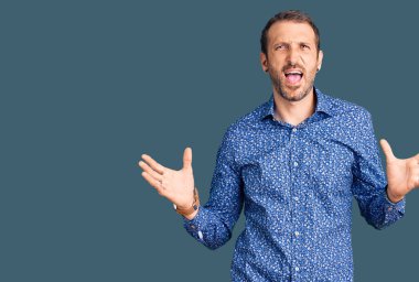 Genç, yakışıklı, sıradan kıyafetler giyen çılgın ve deli gibi bağıran agresif bir ifade ve kollarla bağıran bir adam. hüsran kavramı. 