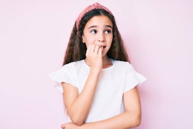 Gündelik kıyafetler ve diyabet giyen tatlı İspanyol kız elleri ağızda tırnak yerken stresli ve gergin görünüyor. anksiyete. 