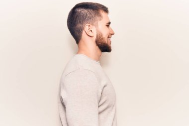 Genç yakışıklı bir adam sıradan bir süveter giyiyor, rahat bir profil çiziyor, doğal bir yüz ifadesi ve kendine güvenen bir gülümsemesi var.. 