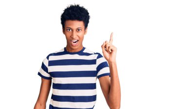 Gündelik giysiler giymiş genç Afro-Amerikan bir adam başarılı bir fikri işaret ediyor. Heyecanlı ve mutlu. Bir numara.. 