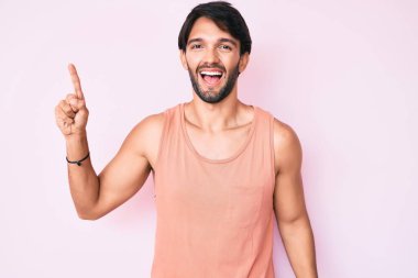 Sıradan kıyafetler giyen yakışıklı İspanyol adam başarılı bir fikirle işaret ediyor. Heyecanlı ve mutlu. Bir numara.. 