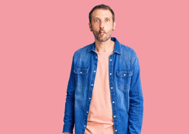 Gündelik kıyafetler giyen genç yakışıklı adam dudaklarıyla balık suratı yapıyor, çılgınca ve komik bir jest. Komik ifade. 