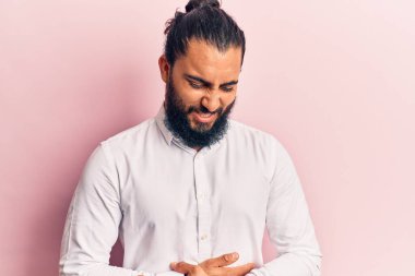 Genç Arap adam midesi üstünde günlük kıyafetler giyiyor çünkü hazımsızlık, acı verici bir hastalık kendini iyi hissetmiyor. Ağrı kavramı. 