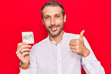 Elinde gülümseyerek mutlu ve olumlu gülümseyen genç bir adam var. Başparmağınla mükemmel ve onay işareti yapıyorsun. 